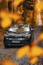 A car in autumn forest, surrounded by orange leaves, electric car, VW ID 5, Gechingen, Black