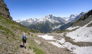 Mountaineer on hiking trail, mountain landscape, view of mountain peak Aiguille Verte of the Mont