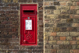 Red letterbox built into a brick wall, typical of urban England, Kew, London, England, Great