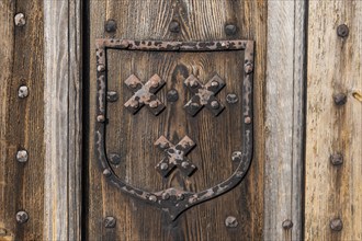 Old wooden door with hand-forged fittings, coat of arms, former Hanseatic city of Visby, UNESCO