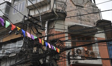 Messy entangled electricity, telecommunication wires, cables on poles in Hanoi, Vietnam, Asia