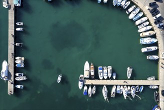 Drone aerial scenery of a fishing port. Fishing boats and yachts moored in the harbour. Cyprus