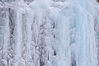 Texture of blue icicles on icy wall of rocks