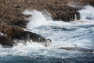 Waves crashing on rocky coast. Windy weather, Powerful sea waves braking on rocks