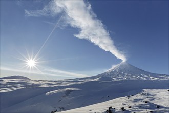 Winter view of eruption active Klyuchevskoy Volcano (Klyuchevskaya Sopka) and sun rays on beautiful