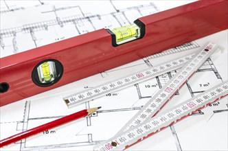 Spirit level, pencil and yardstick on a construction plan