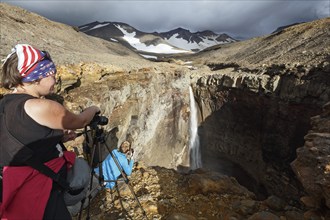 MUTNOVSKY VOLCANO, KAMCHATKA PENINSULA, RUSSIA, SEP 8, 2015: Young women tourists photographers