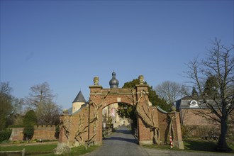 Historic Tor tor with brick arch and tower in a castle complex, surrounded by bare trees, borken,