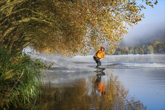 Essen, North Rhine-Westphalia, Germany, Golden autumn on Lake Baldeney. Wakeboarder in the morning