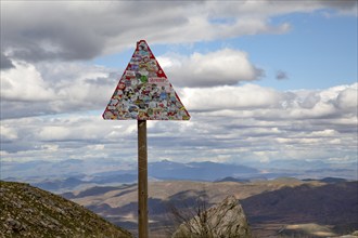 Street sign covered with stickers beyond recognition