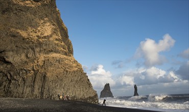 Unrecognised people sightseeing at reynisfjara black sand beach in Vik I mydral south Iceland.