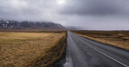 Highway countryside straight empty road leading to the snowy mountains at snaefellsnes peninsula in