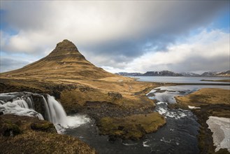 The Kirkjufell mountain and the kirkjufellfoss waterfall at grundarfjordur at Snaefellsnes