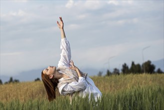 Young dancer woman dancing outdoors. Modern dance performance in the meadow field. Carefree and