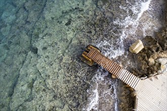 Drone aerial top view of abandoned pier in the sea. Transportation infrastructure