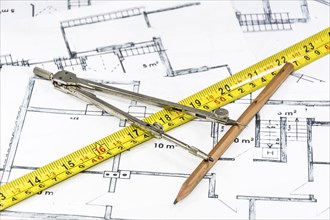 Compass calipers and pencil lying on construction plan