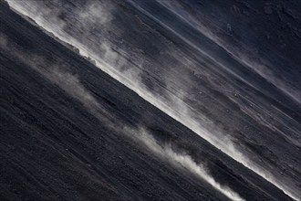 Smoke rises diagonally from the slope of a volcano