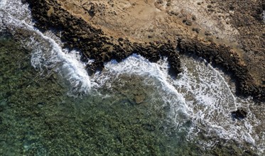 Drone aerial of rocky sea coast with transparent turquoise water. Seascape top view, Protaras