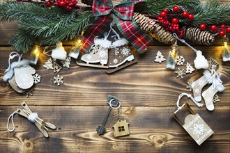 House key with keychain cottage on a festive eco friendly, natural background with Christmas tree.