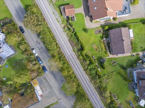 Aerial view of a railway track running through a residential area with adjoining streets and