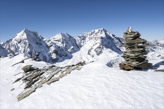 Cairns in the snow, mountain panorama with snow-covered mountain landscape in winter, view of