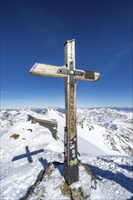 Summit cross on the summit of Monte Cevedale, snow-covered mountain landscape in winter, Ortler