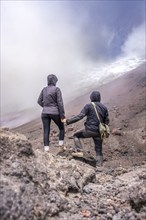 Couple standing in front of the Cotopaxi, Cotopaxi, Cotopaxi National Park, Latacunga, Ecuador,