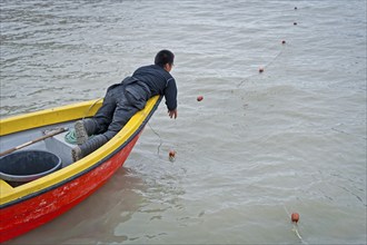 Inuit hunter sets a net, near the Inuit settlement Tiniteqilaaq or Greenlandic Tiilerilaaq,