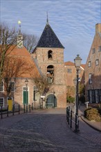 Alley in Greetsiel with a view of the bell tower of the Protestant Reformed Church, Greetsiel,