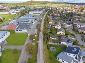 Aerial view of a railway track through a mixed area with residential and commercial buildings,