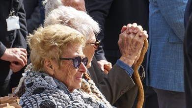 Survivors of the massacre of 3.6.1941, Elderly people sit together, one holds a walking stick at a