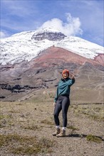 Women poses in front of the Cotopaxi volcano, Cotopaxi, Cotopaxi National Park, Latacunga, Ecuador,