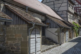 Former storage rooms, barns from the 15th century, in the historic fortified church, Hüttenheim,