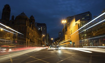 Light trails of cars and buses moving with speed at Piccadilly avenue near the main train station