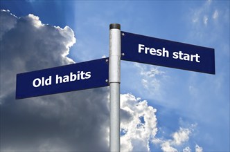 Street sign in front of dark clouds symbolizing choice between 'old habits' and a 'fresh start'