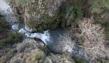 Drone aerial of waterfall flowing from a rocky cliff in the gorge. River flowing in autumn. Nature