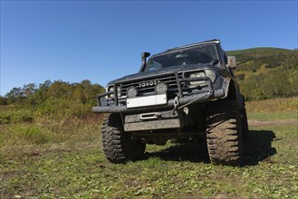 Sport utility vehicle Toyota Land Cruiser Prado on mountain autumn forest landscape, popular travel