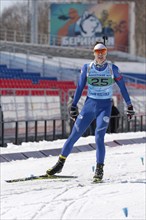 Kamchatka sportsman biathlete Ageev Danil in action skiing on ski track distance biathlon arena.