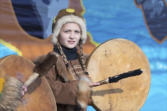 Girl dancing with tambourine in tradition clothing aborigine people Kamchatka Peninsula. Concert,