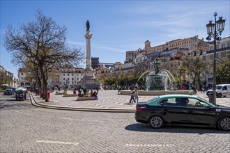 Praça do Rossio in Lisbon, Spacious city square with cars, statue and lively atmosphere under a