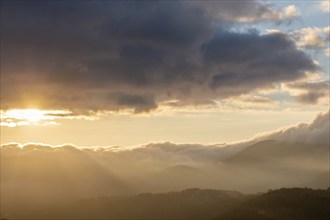 Mist in the mountains in autumn. The evening sun lights up the valleys. France Europe, Vosges