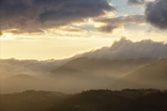 Mist in the mountains in autumn. The evening sun lights up the valleys. France Europe, Vosges