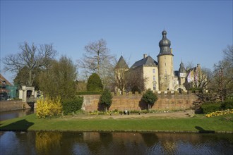 Castle with moat and park in spring light, framed by trees, borken, North Rhine-Westphalia, germany