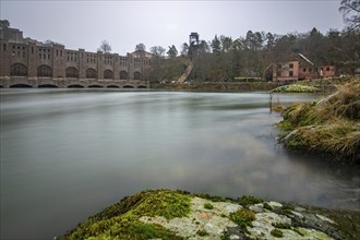 Historic sight, the red brick hydroelectric power plant power station. Rainy weather at sunset by