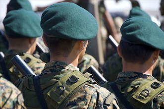 Military soldiers parading in uniform and armed with guns