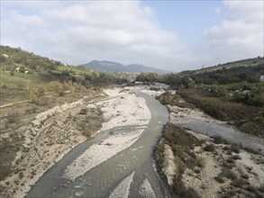 Muddy water flowing in the arda river near mignano val tolla in piacenza, italy, creating small