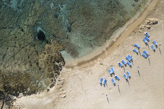 Drone aerial of beach umbrellas in the beach. Summer holidays in the sea