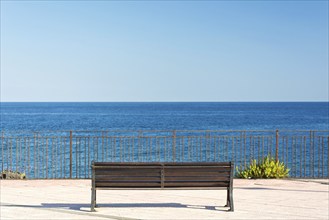 Lonely bench facing beautiful ocean panorama on Sicily, Italy, Europe