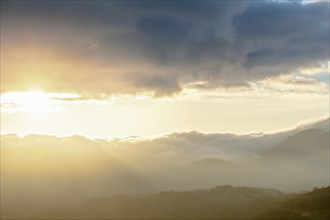 Mist in the mountains in autumn. The evening sun lights up the valleys. France Europe, Vosges