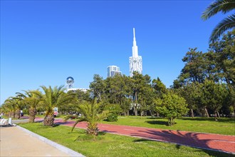 Park with palm trees near promenade of Batumi, Georgia and high modern houses